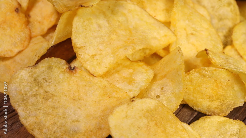 Potato chips on wooden background. Macro shot. Potato chips on wooden background. Macro shot.