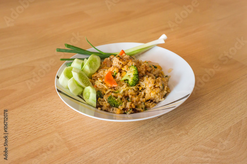 Thai food - fried rice on white dish with wood background, selective focus on front object