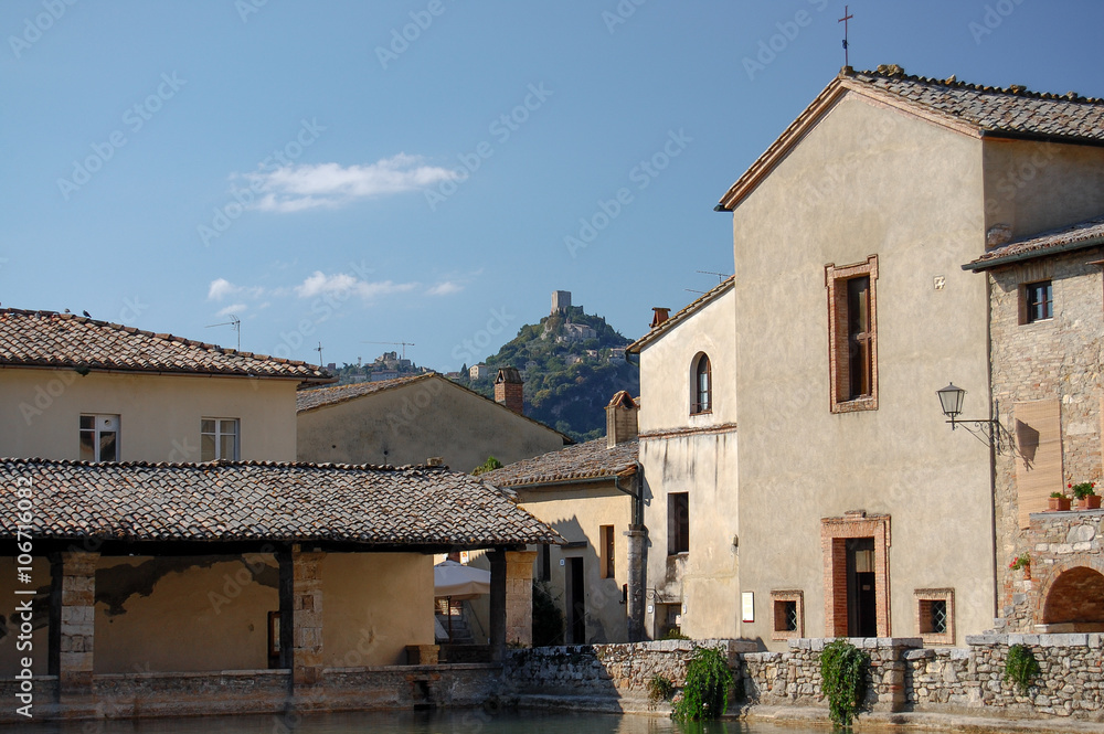 homes surrounding the a thermal pool in the small town and the castle on the hill