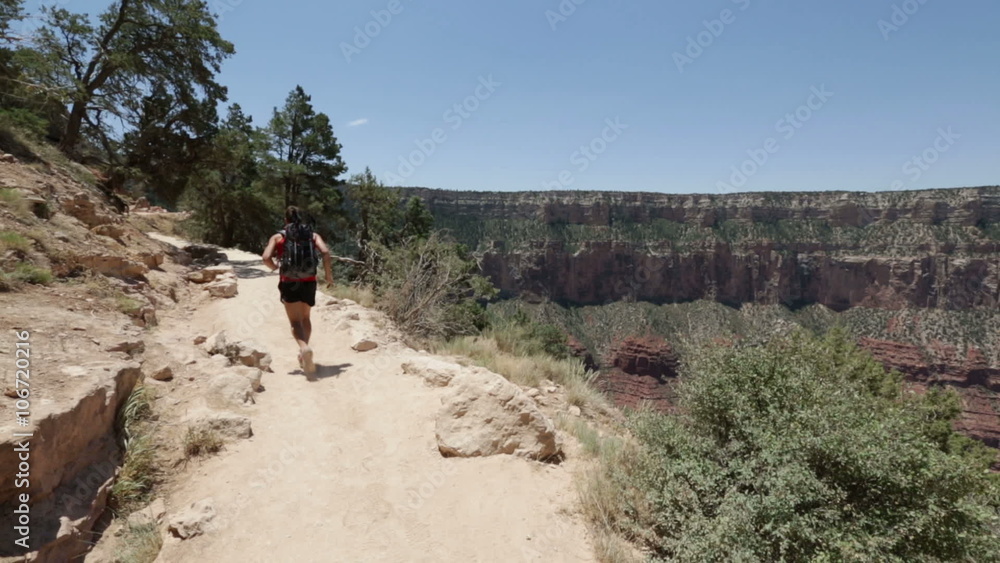 Running cross-country runner man in race on path in Grand Canyon, USA. Fit sports athlete jogging and training in beautiful nature landscape. Fit Caucasian fitness model in his 20s. Running cross-country runner man in race on path in Grand Canyon, USA. Fit sports athlete jogging and training in beautiful nature landscape. Fit Caucasian fitness model in his 20s.
