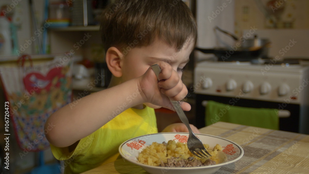 Boy of three years in the yellow shirt is eating Boy of three years in the yellow shirt is eating