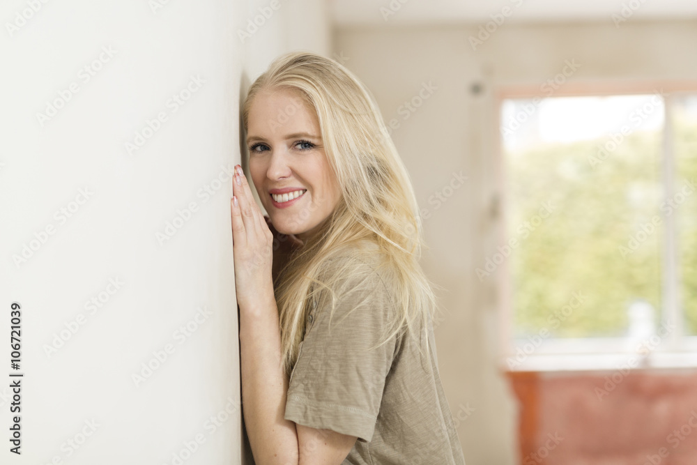 Portrait of smiling young woman leaning against wall on construction site Portrait of smiling young woman leaning against wall on construction site