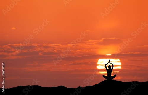 Photography Sunset landscape with girl practicing yoga on the background of sun and red sky