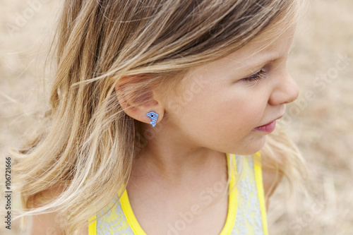 Portrait of little girl wearing a dolphin earring photo