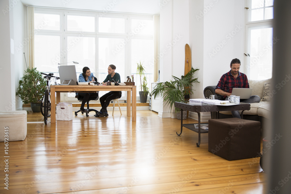 Three creative business people working in informal office Three creative business people working in informal office