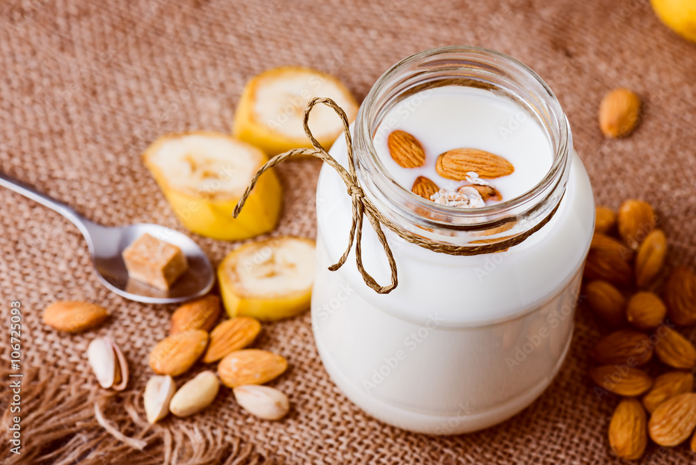 Banana and almond milk smoothie in a jar on a burlap Banana and almond milk smoothie in a jar on a burlap