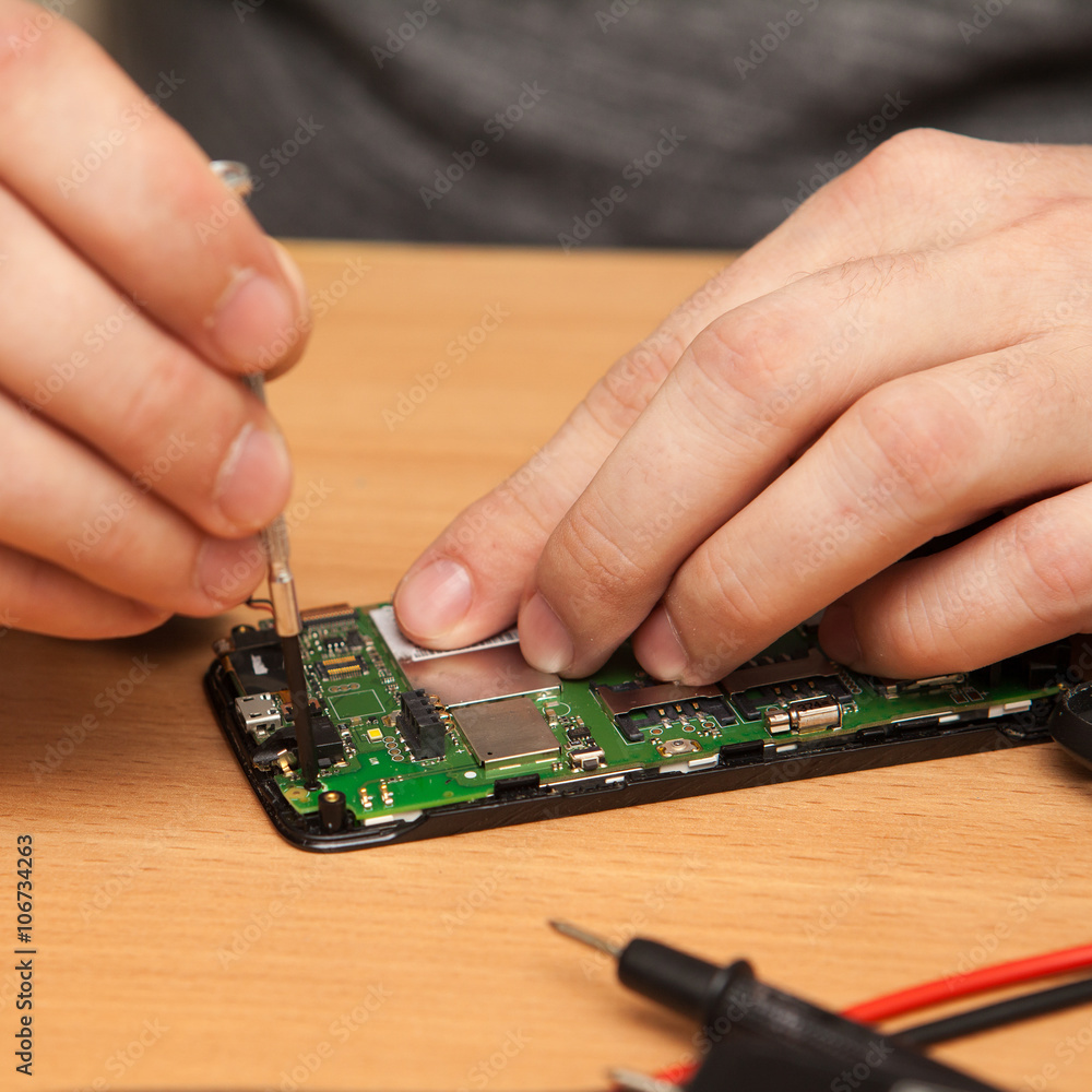 repairer to disassemble the smartphone. Hands close-up. repairer to disassemble the smartphone. Hands close-up.