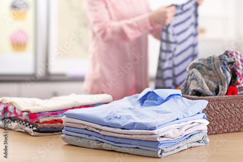 Woman putting together clothes in the room