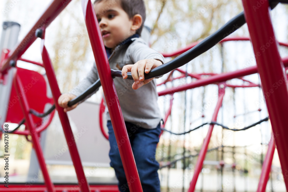 Toddler playing on red playground equipment Toddler playing on red playground equipment