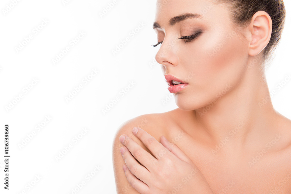 Close up portrait of minded woman touching her shoulder on white Close up portrait of minded woman touching her shoulder on white