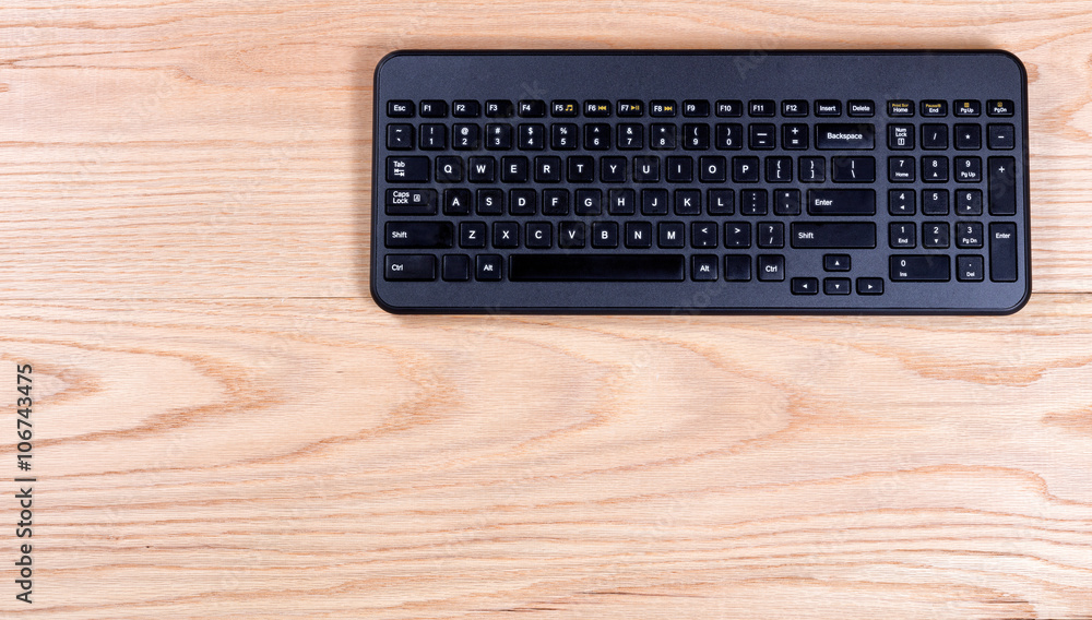 Clean and organized oak desktop with modern wireless keyboard Clean and organized oak desktop with modern wireless keyboard