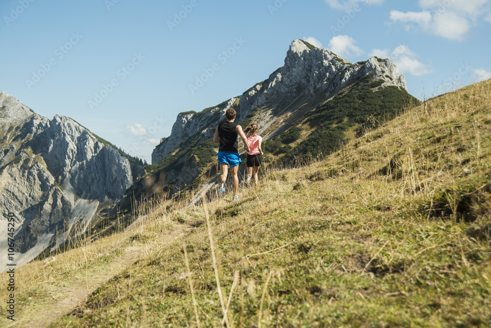 Austria, Tyrol, Tannheim Valley, young couple jogging in mountains Austria, Tyrol, Tannheim Valley, young couple jogging in mountains