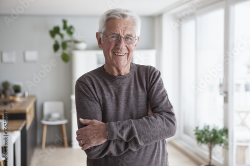Portrait of smiling senior man at home photo