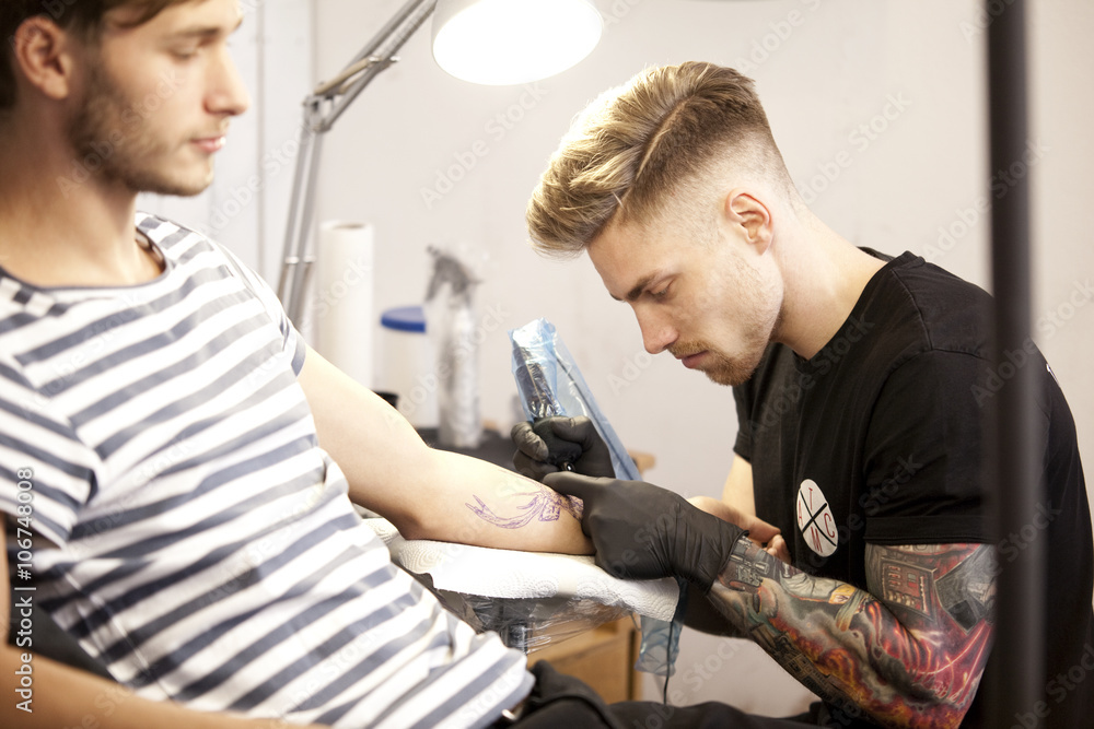 Tattooist at work in his tattoo studio Tattooist at work in his tattoo studio