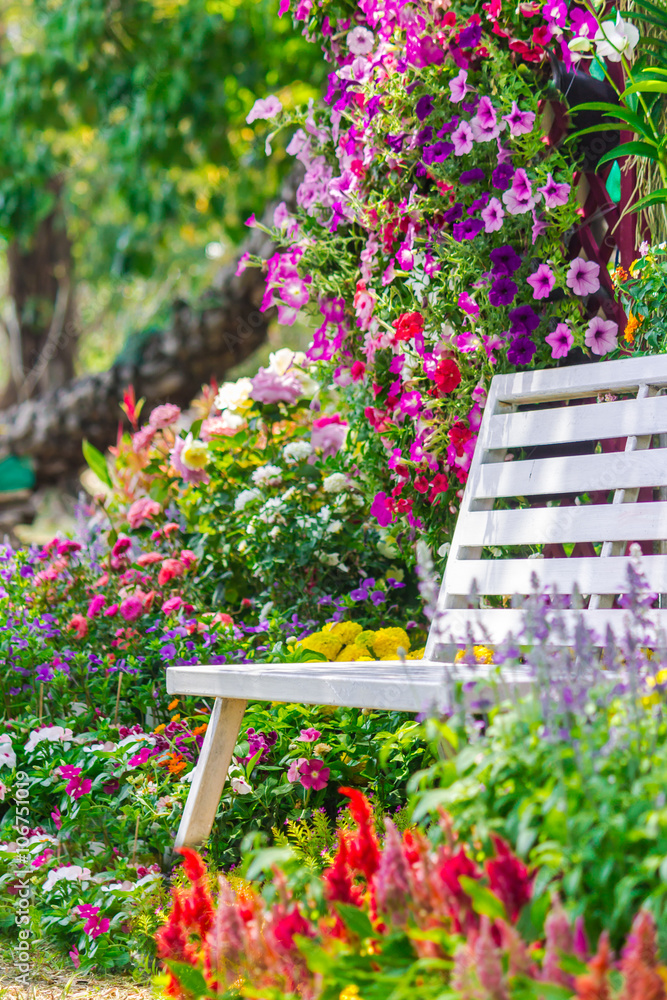 Obraz premium White Wood chair in the flowers garden./ White Wood chair in the flowers garden on summer. 