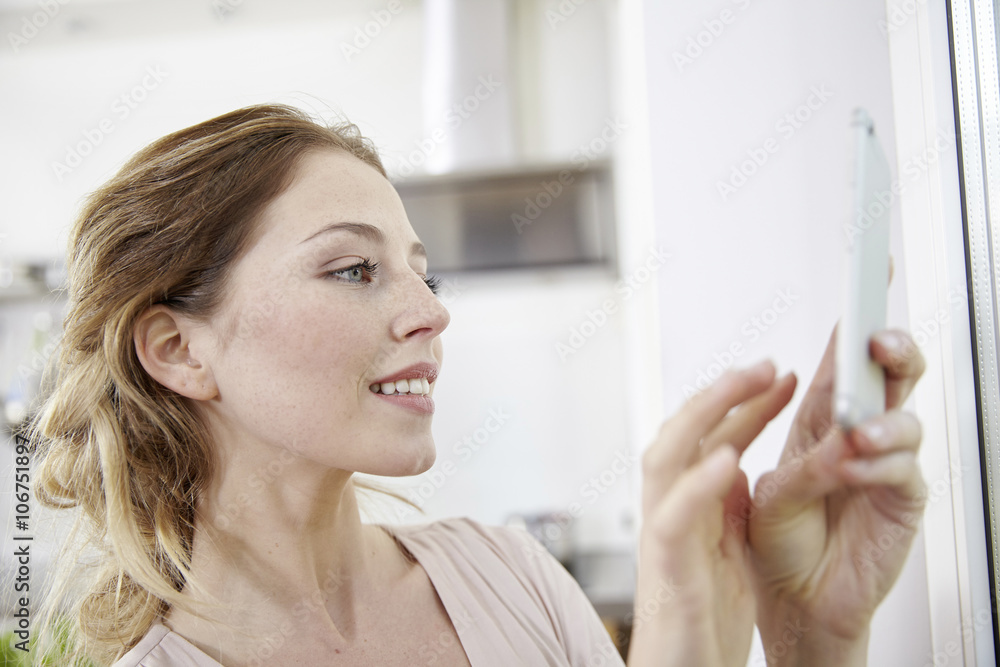 Smiling young woman text messaging
