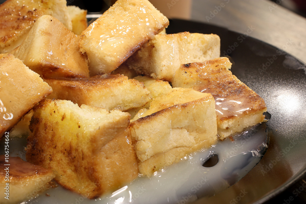 Bread toast with butter and condensed milk in a plate, select focus Bread toast with butter and condensed milk in a plate, select focus