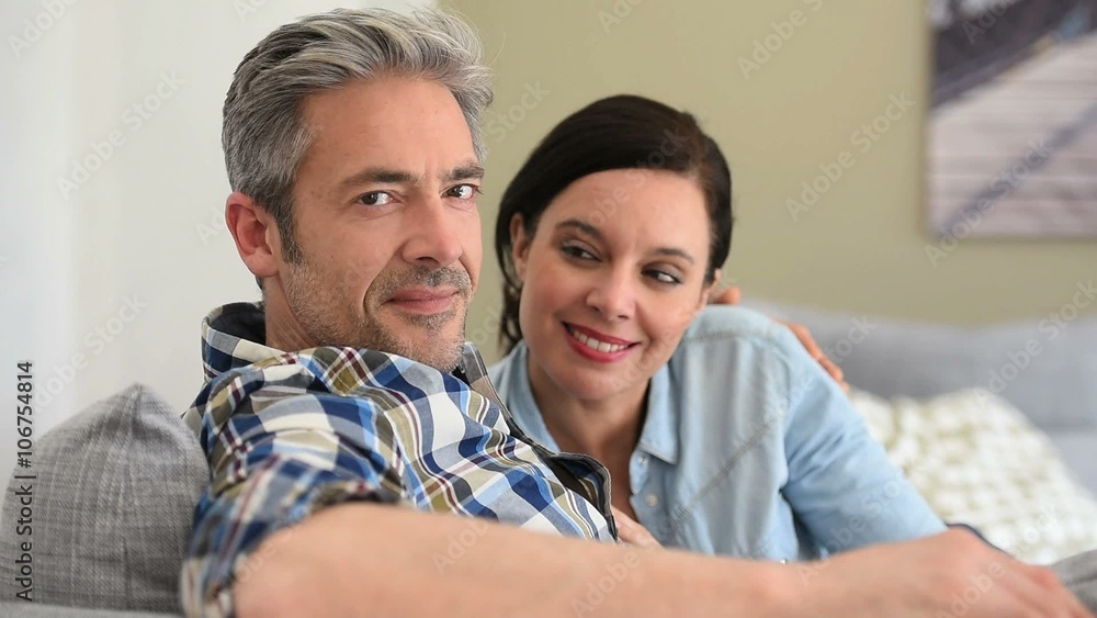 Middle-aged couple relaxing in sofa at thome Middle-aged couple relaxing in sofa at thome