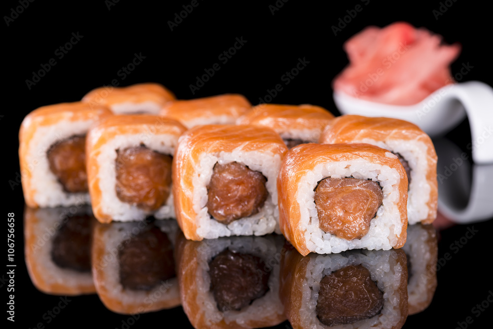 Sushi Roll with salmon over  black background with reflection