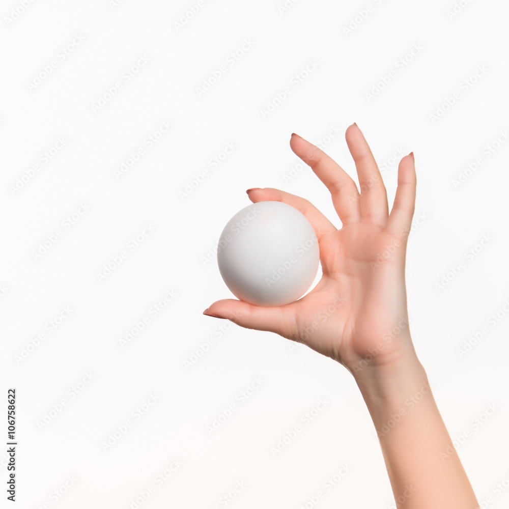 The female hand holding white blank styrofoam ball The female hand holding white blank styrofoam ball