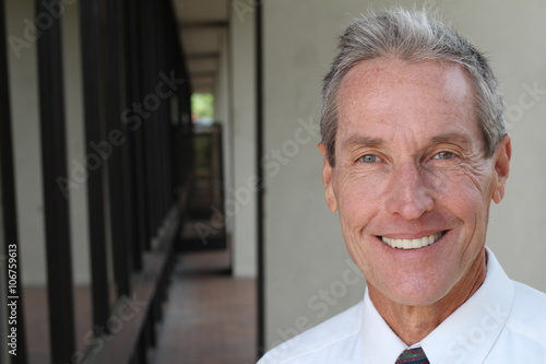 Handsome man with grey hair looking to the camera with copy space  photo