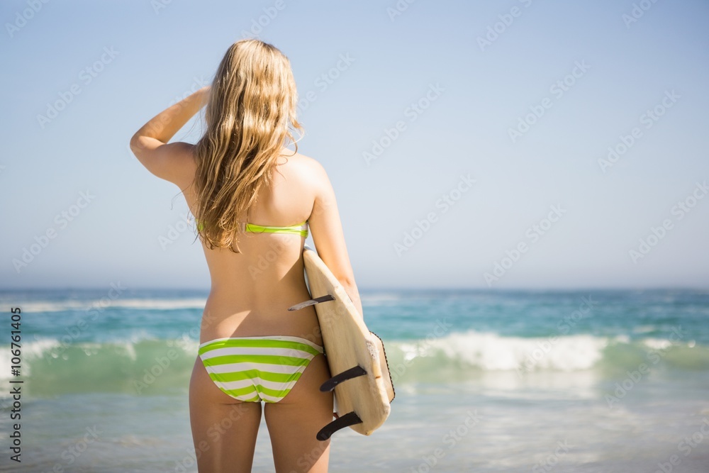 Blonde woman holding surfboard