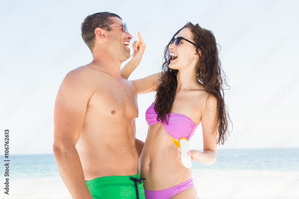 Girlfriend applying sun cream on boyfriend Girlfriend applying sun cream on boyfriend