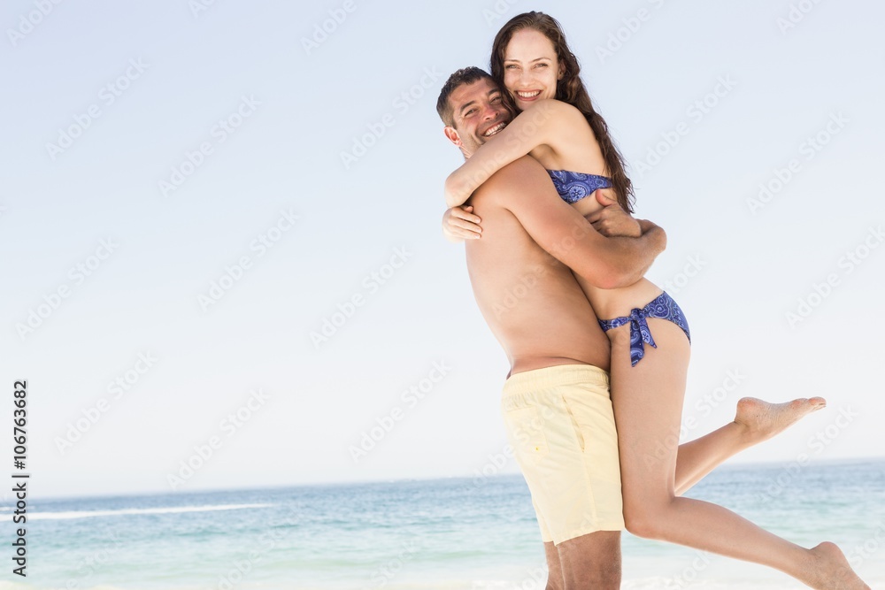 Smiling couple embracing on the beach Smiling couple embracing on the beach