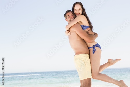 Smiling couple embracing on the beach