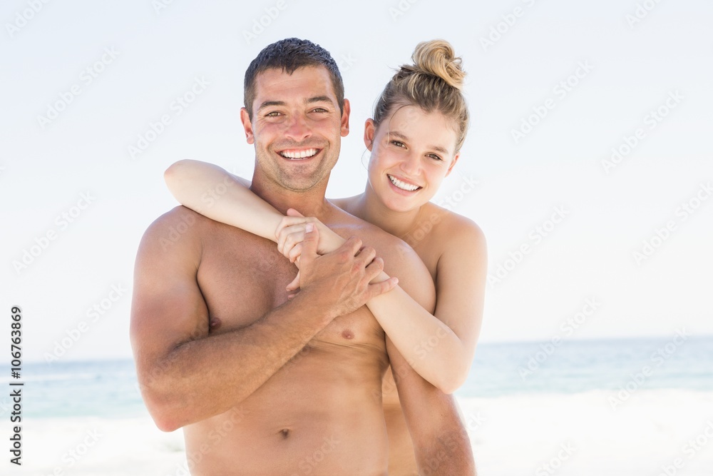 Smiling couple embracing on the beach Smiling couple embracing on the beach