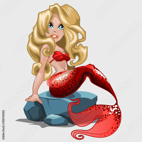 Blonde mermaid in red swimsuit sits on a rock