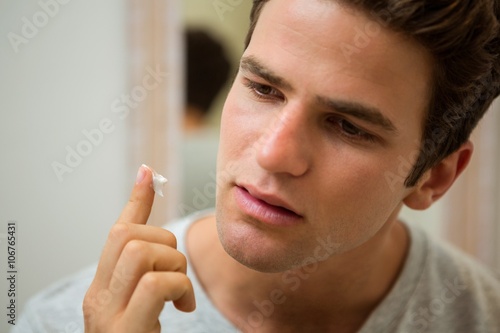 Man applying moisturizer on his face