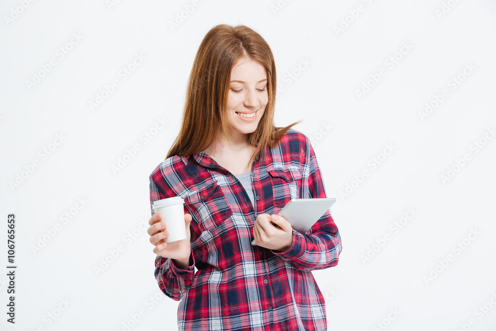 Woman using tablet computer and holding cup with coffee Woman using tablet computer and holding cup with coffee