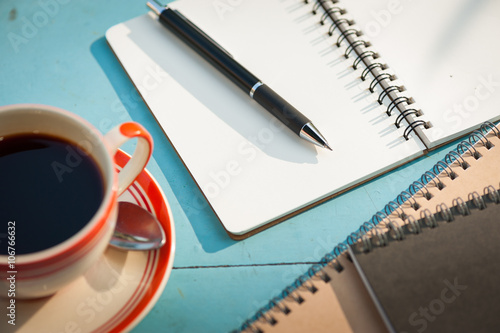 Notenook and coffee cup on wood table