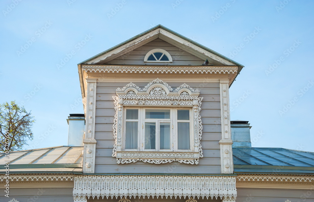 Obraz premium Attic window of a wooden house decorated with wood carvings