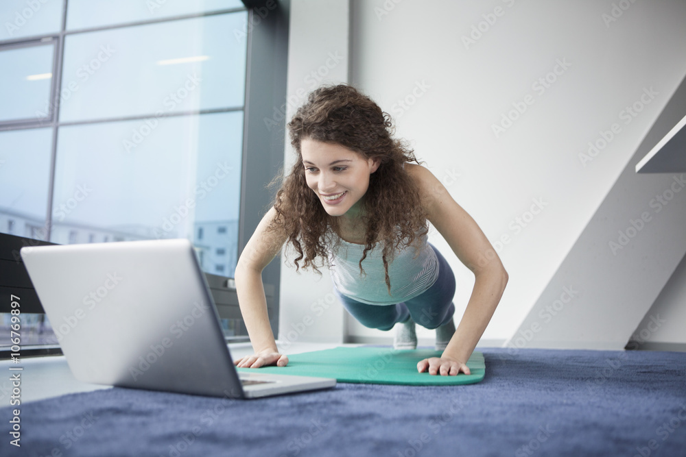 Woman doing gymnastics with laptop Woman doing gymnastics with laptop