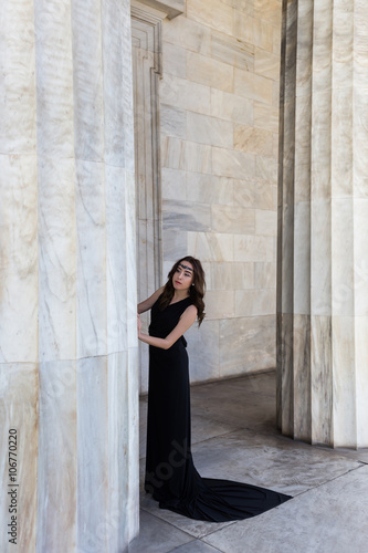 Fototapete young lady in black dress near column