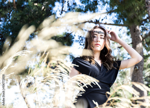 Fototapete portrait of young lady in black through grass