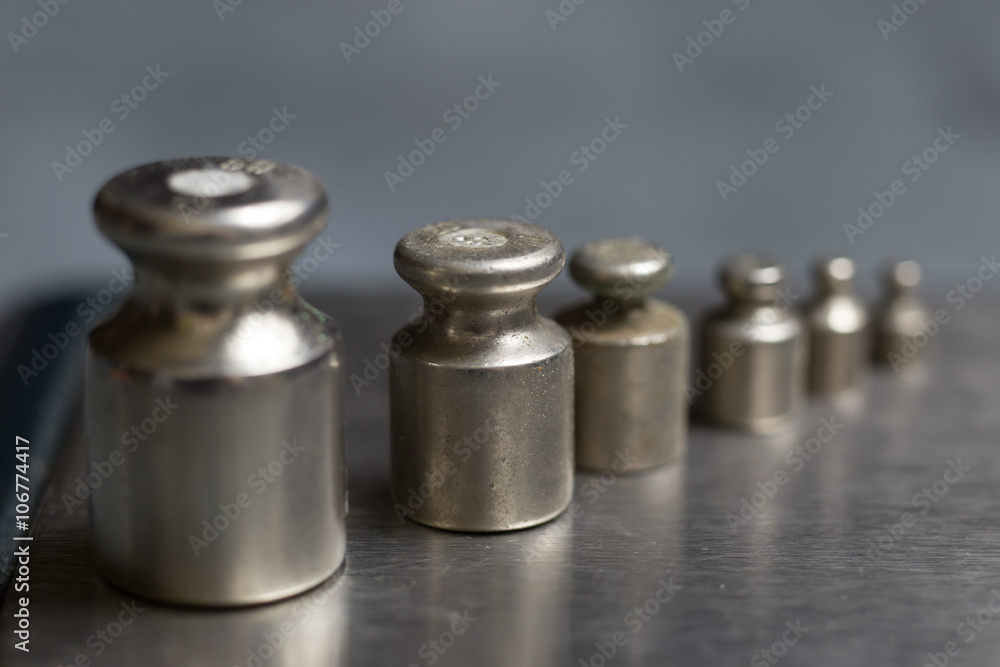 Plummets set on weigh-scales. Jewelry workplace on metal background with copy space for text. Plummets set on weigh-scales. Jewelry workplace on metal background with copy space for text.
