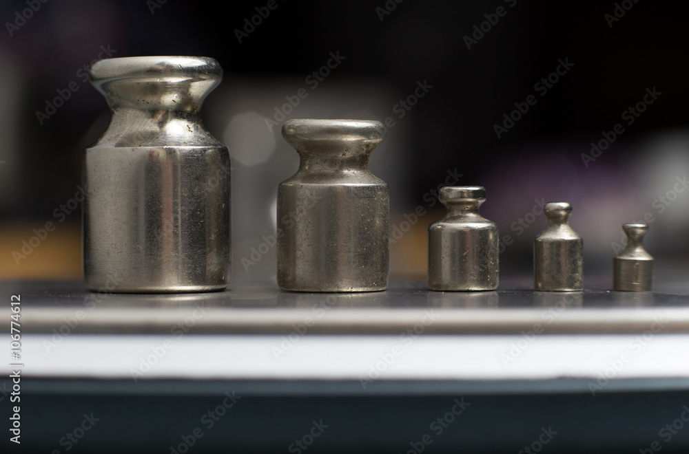 Plummets set on weigh-scales. Jewelry workplace on metal background with copy space for text. Plummets set on weigh-scales. Jewelry workplace on metal background with copy space for text.
