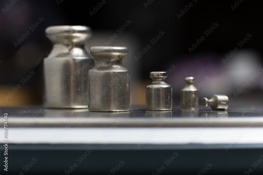 Plummets set on weigh-scales. Jewelry workplace on metal background with copy space for text. Plummets set on weigh-scales. Jewelry workplace on metal background with copy space for text.