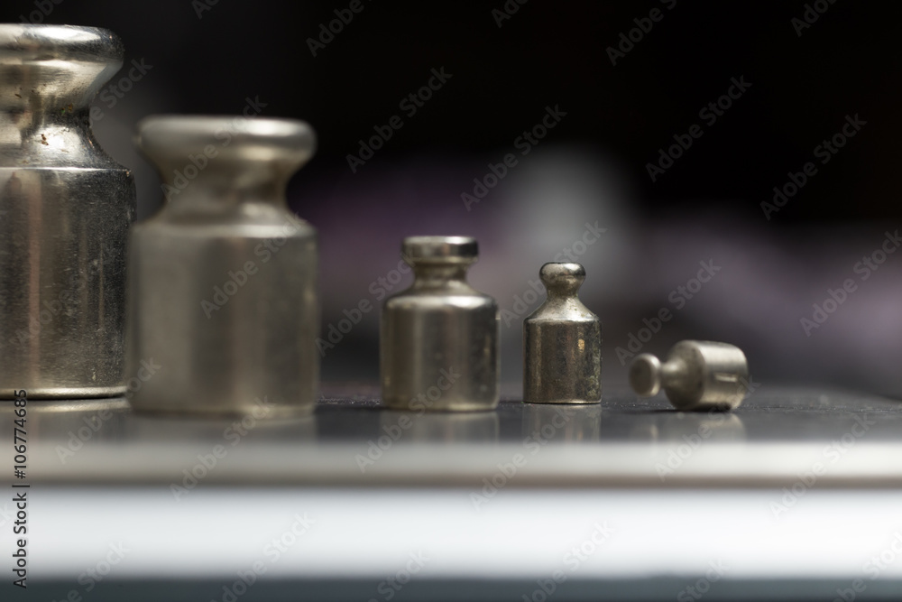 Plummets set on weigh-scales. Jewelry workplace on metal background with copy space for text. Plummets set on weigh-scales. Jewelry workplace on metal background with copy space for text.