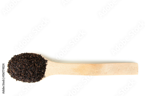 wooden spoon full of loose tea on white isolated background