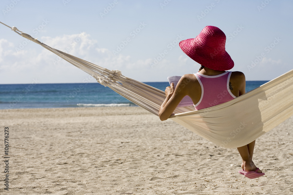 femme dans un hamac à la plage Photos | Adobe Stock