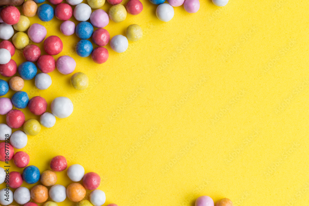 Candies colorful mix on yellow bright background with copy space Candies colorful mix on yellow bright background with copy space