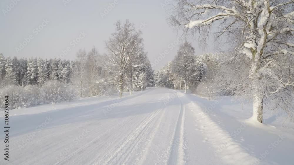 A white car running fast on the snowy street. The street is covered with snow and the trees on the side of the street A white car running fast on the snowy street. The street is covered with snow and the trees on the side of the street