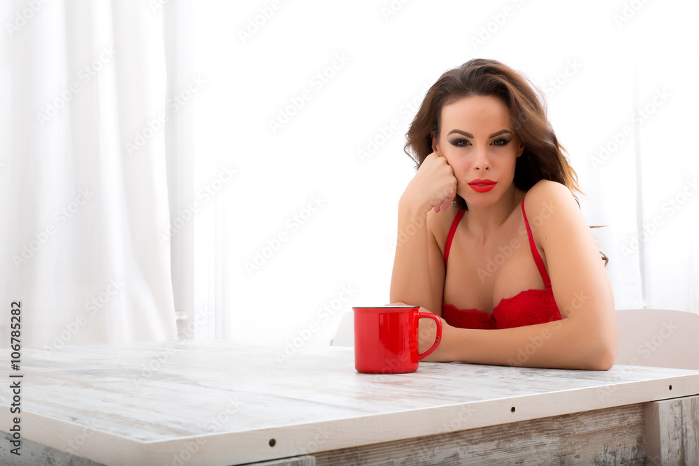 Young woman in underwear drinking her first coffee of the day Young woman in underwear drinking her first coffee of the day