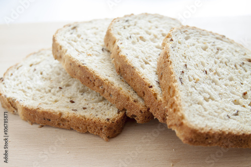 Pane integrale a fette su tagliere di legno