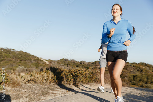Sport runner jogging on beach working out with her partner