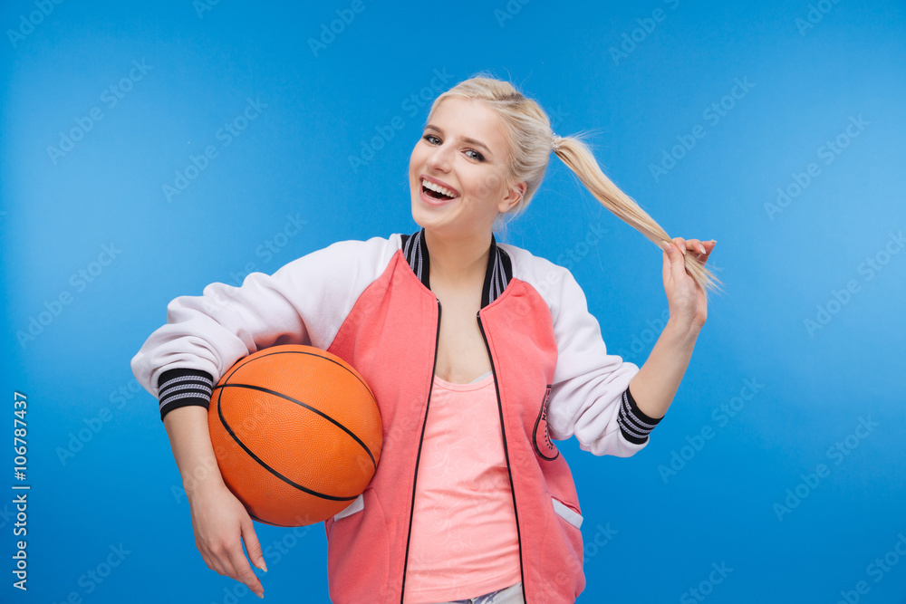 Cheerful female student holding basketball ball